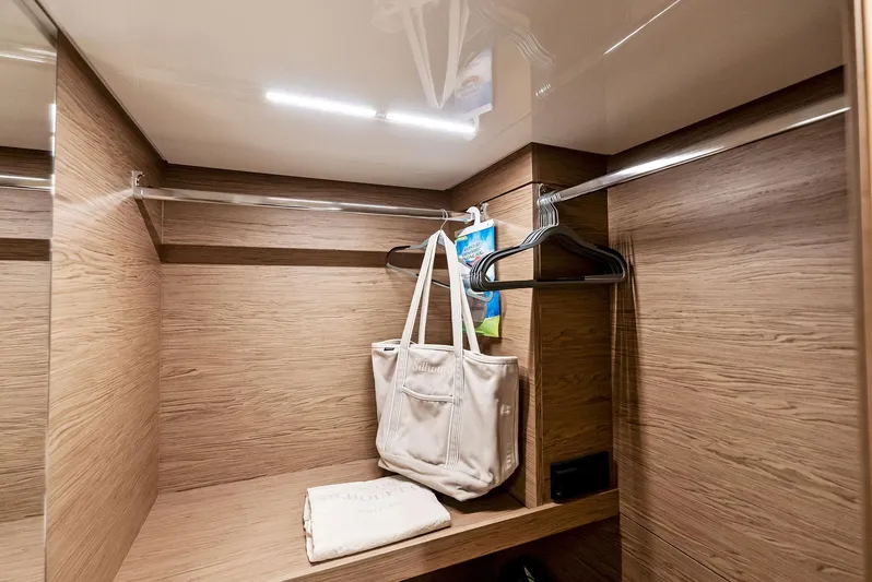  Yacht Photos Pics Luxurious wooden closet interior on 2020 Ferretti Yachts 920, featuring hangers and a white bag.