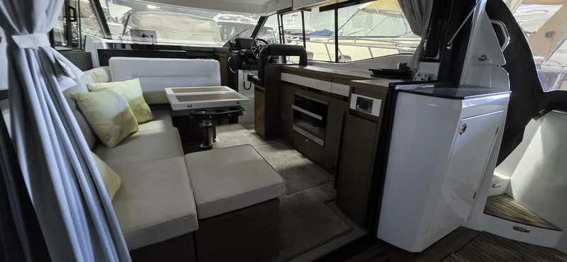  Yacht Photos Pics 2020 Jeanneau NC 37 interior with modern seating, table, and helm.