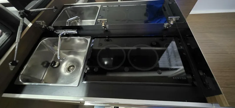  Yacht Photos Pics Modern kitchen area in a 2020 Jeanneau NC 37 boat, featuring a sink and stove.