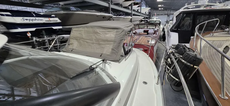  Yacht Photos Pics 2020 Jeanneau NC 37 yacht in a showroom, surrounded by other boats.