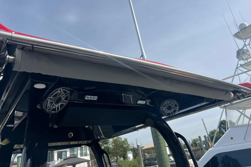  Yacht Photos Pics 2021 Fountain 39 NX boat with speakers and canopy, docked under clear sky.