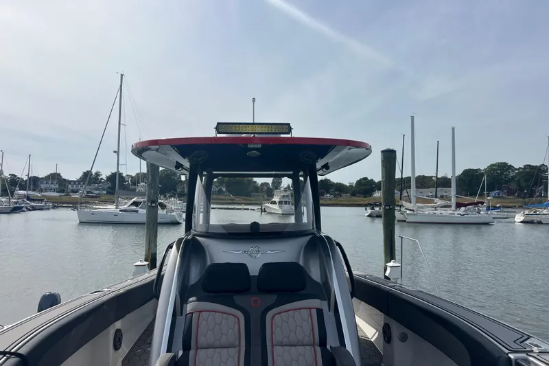  Yacht Photos Pics 2021 Fountain 39 NX boat docked in a marina with sailboats in the background.