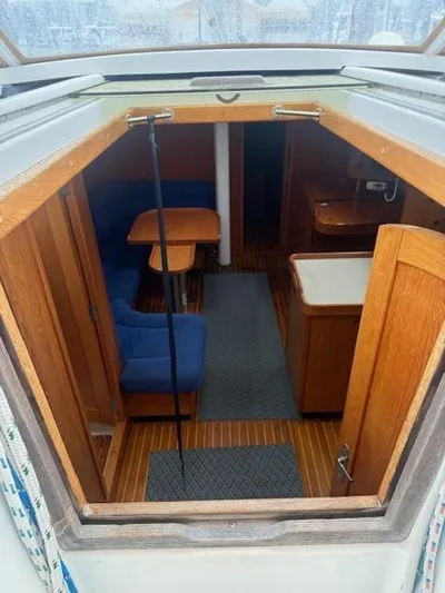 Jet Stream Yacht Photos Pics Interior view of 2003 Wauquiez Centurion 45s sailboat, featuring wooden furnishings and blue seating.