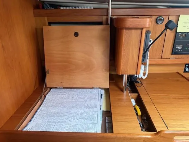 Jet Stream Yacht Photos Pics Navigation station inside 2003 Wauquiez Centurion 45s yacht with wooden cabinetry and charts.