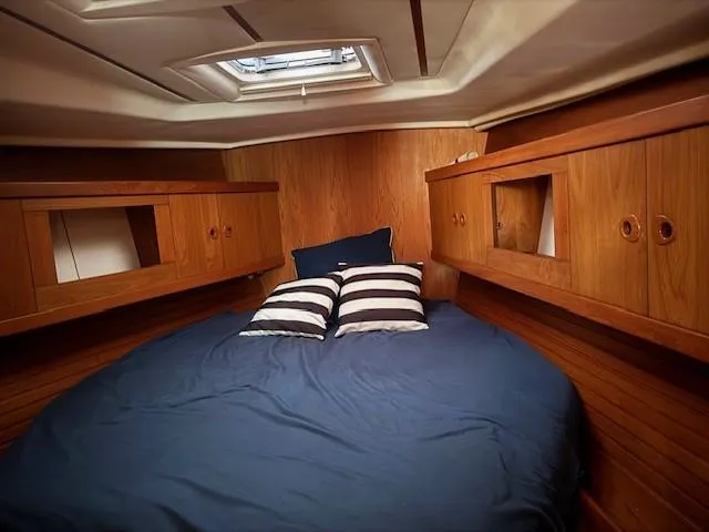 Jet Stream Yacht Photos Pics Cozy cabin interior of 2003 Wauquiez Centurion 45s with wooden finish and blue bedding.