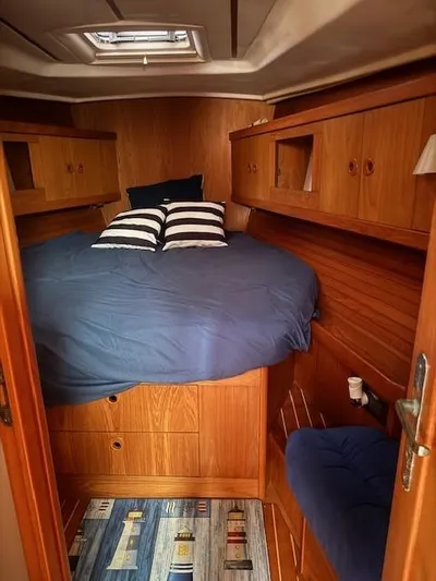 Jet Stream Yacht Photos Pics Cozy cabin interior of 2003 Wauquiez Centurion 45s sailboat with wood finish and blue bedding.