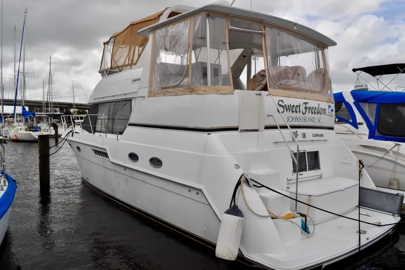 Sweet Freedom Yacht Photos Pics 1999 Carver 406 Aft Cabin Motor Yacht docked at marina, overcast sky.