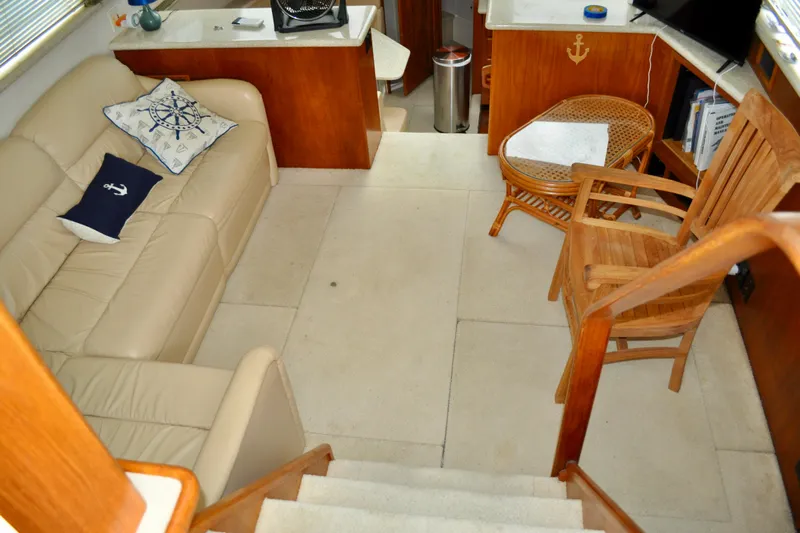 Sweet Freedom Yacht Photos Pics Interior of 1999 Carver 406 Aft Cabin Motor Yacht with beige sofa and wooden chairs.