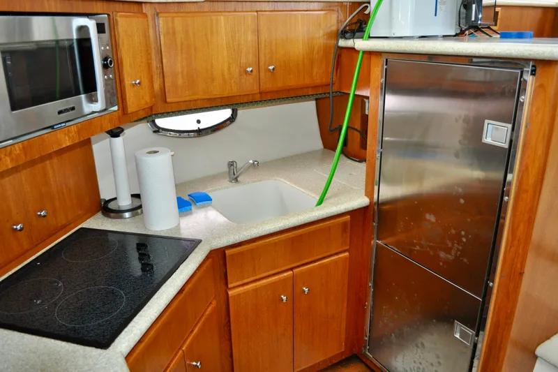 Sweet Freedom Yacht Photos Pics 1999 Carver 406 Aft Cabin Motor Yacht kitchen with microwave, stove, and stainless steel fridge.