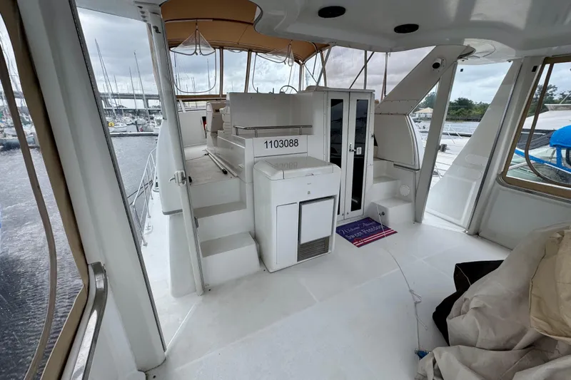 Sweet Freedom Yacht Photos Pics 1999 Carver 406 Aft Cabin Motor Yacht interior with marina view, featuring seating and storage.