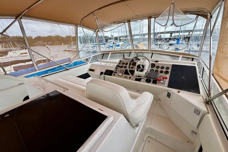 Sweet Freedom Yacht Photos Pics 1999 Carver 406 Aft Cabin Motor Yacht helm with marina view, featuring steering wheel and controls.