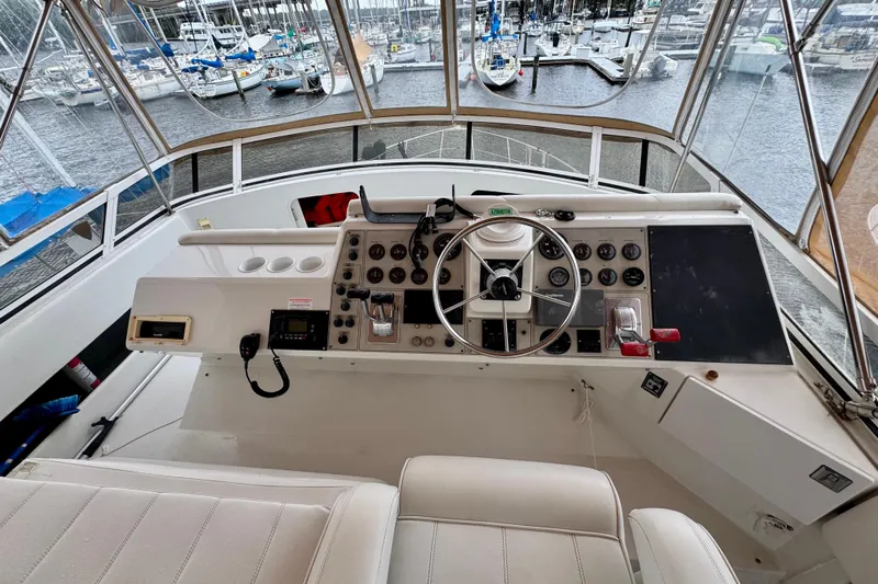 Sweet Freedom Yacht Photos Pics 1999 Carver 406 Aft Cabin Motor Yacht helm with marina view, featuring steering wheel and controls.