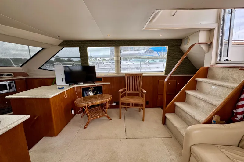 Sweet Freedom Yacht Photos Pics 1999 Carver 406 Aft Cabin Motor Yacht interior with TV, table, and stairs.
