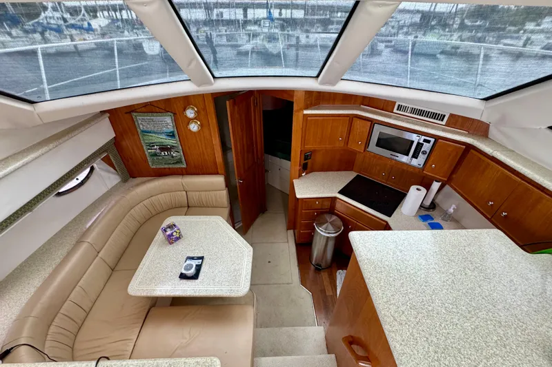 Sweet Freedom Yacht Photos Pics 1999 Carver 406 Aft Cabin Motor Yacht interior with kitchen and seating area.
