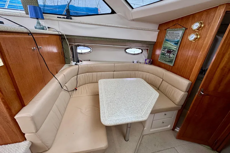 Sweet Freedom Yacht Photos Pics 1999 Carver 406 Aft Cabin Motor Yacht interior with beige seating and dining table.