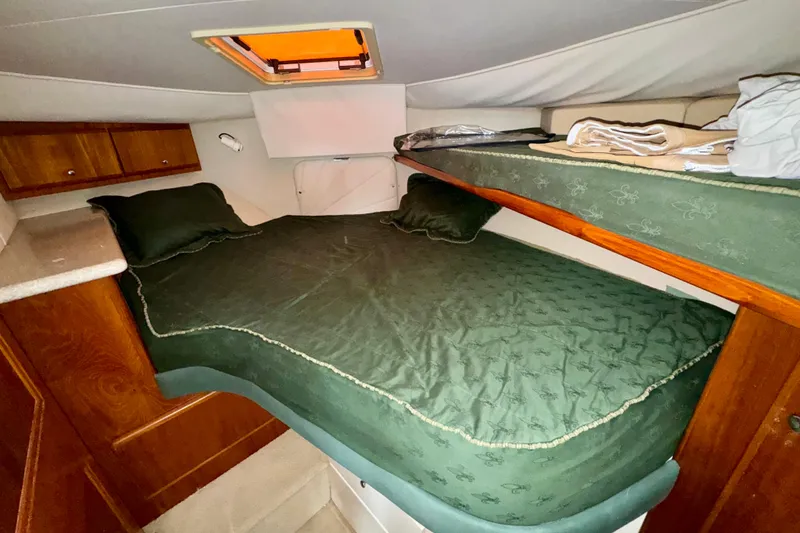 Sweet Freedom Yacht Photos Pics 1999 Carver 406 Aft Cabin Motor Yacht interior with green bedding and wooden cabinets.