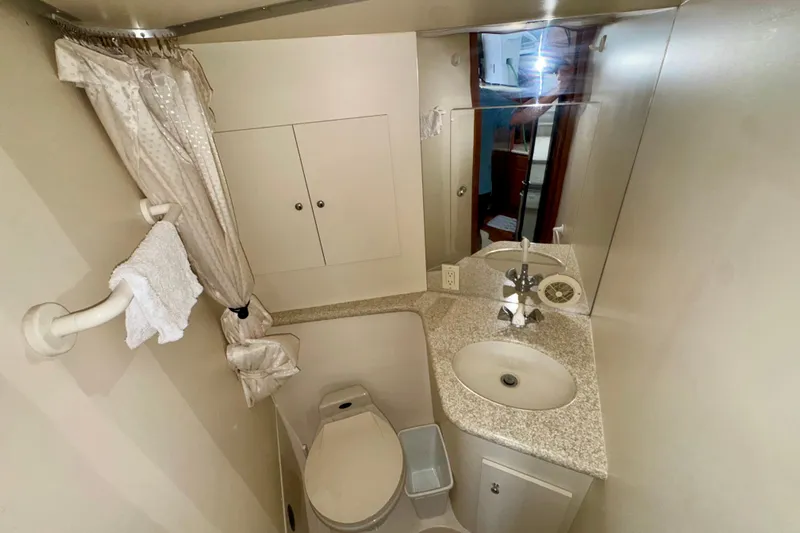 Sweet Freedom Yacht Photos Pics 1999 Carver 406 Aft Cabin Motor Yacht bathroom with sink, toilet, and mirror.