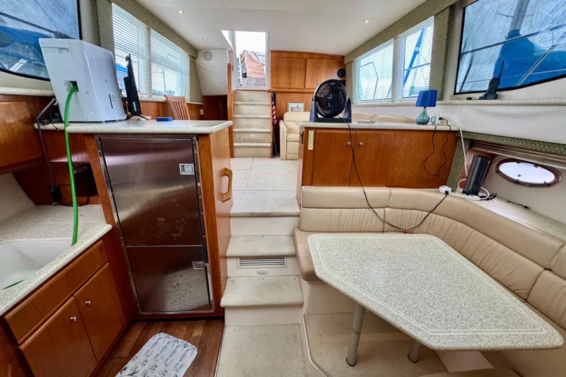 Sweet Freedom Yacht Photos Pics 1999 Carver 406 Aft Cabin Motor Yacht interior with seating, table, and kitchen area.