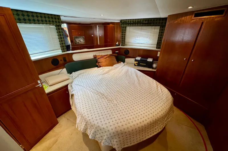 Sweet Freedom Yacht Photos Pics 1999 Carver 406 Aft Cabin Motor Yacht bedroom with cozy bed and wooden cabinetry.