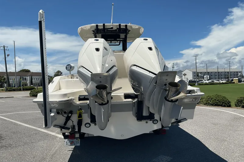  Yacht Photos Pics 2024 Boston Whaler 28 Dauntless boat with dual outboard engines, parked on a sunny day.