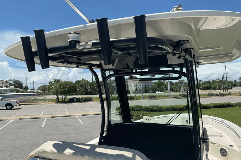  Yacht Photos Pics 2024 Boston Whaler 28 Dauntless boat with T-top and rod holders, parked outdoors.