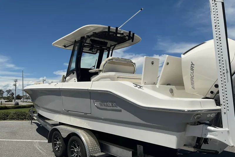  Yacht Photos Pics 2024 Boston Whaler 28 Dauntless boat on trailer, featuring Mercury engine, under clear blue sky.