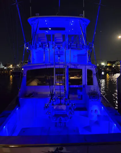In 2 Deep Yacht Photos Pics 1984 Ocean Yachts 46 Super Sport illuminated in blue at night, docked in a marina.