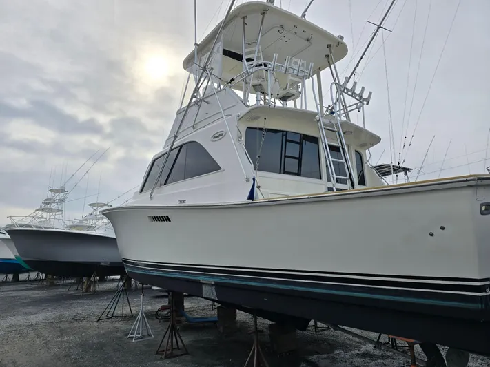 In 2 Deep Yacht Photos Pics 1984 Ocean Yachts 46 Super Sport boat on stands, cloudy sky background.