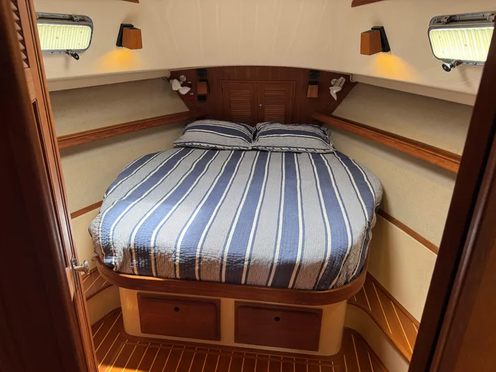 Odyssey Yacht Photos Pics Island Packet 380 yacht cabin interior with striped bedding, wood accents, and soft lighting, 2002 model.