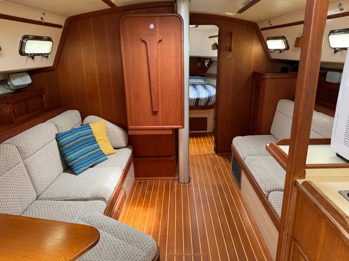 Odyssey Yacht Photos Pics Interior of 2002 Island Packet 380 sailboat with cozy seating and wooden finishes.