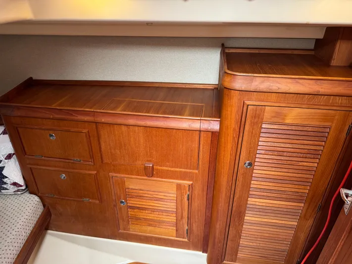 Odyssey Yacht Photos Pics Wooden cabinetry inside a 2002 Island Packet 380 sailboat, featuring drawers and a louvered door.