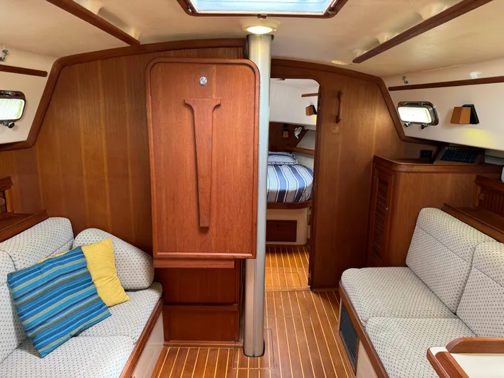 Odyssey Yacht Photos Pics Interior of 2002 Island Packet 380 sailboat with cozy seating and wooden finishes.