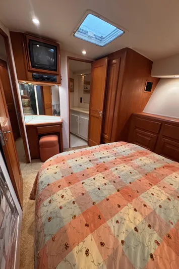  Yacht Photos Pics Cozy bedroom interior of 1996 Viking 50 Convertible yacht with TV and skylight.