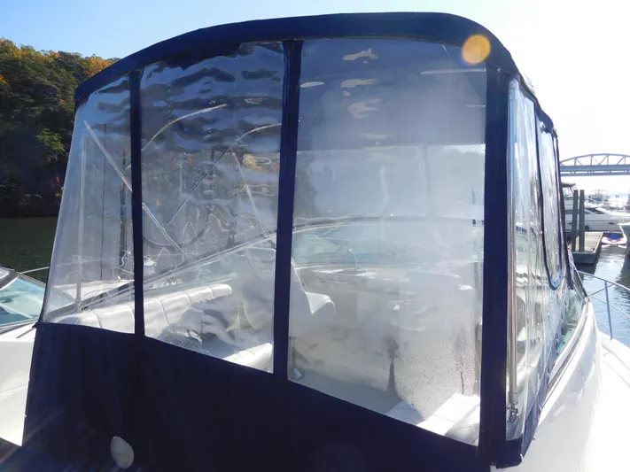  Yacht Photos Pics 2006 Carver 36 Mariner with clear enclosure, docked near a bridge.