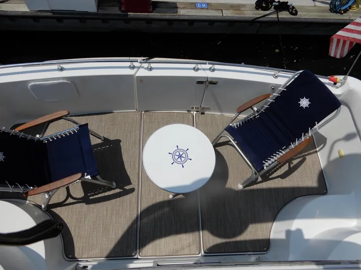  Yacht Photos Pics 2006 Carver 36 Mariner deck with two chairs and a nautical-themed table.