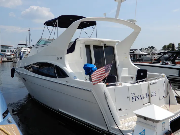  Yacht Photos Pics 2006 Carver 36 Mariner yacht docked at marina, featuring sleek design and American flag.