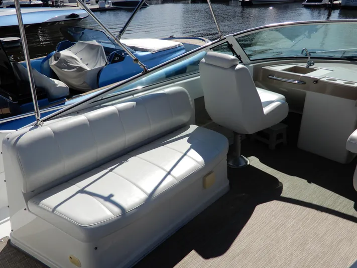  Yacht Photos Pics 2006 Carver 36 Mariner interior with white seating and helm, docked by the water.