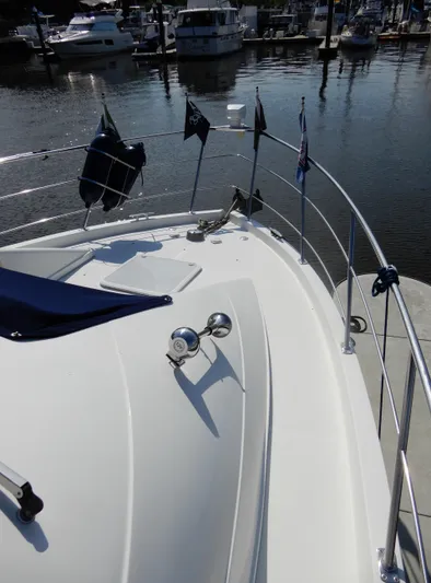 Yacht Photos Pics 2006 Carver 36 Mariner yacht bow with flags, docked in a marina.