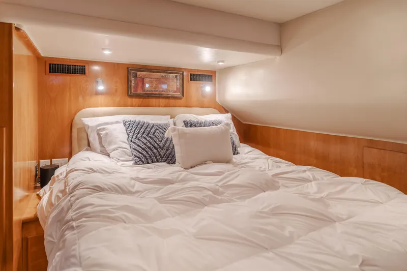 Love Life Yacht Photos Pics Cozy bedroom in 2007 Navigator Pilothouse yacht with plush bedding and ambient lighting.