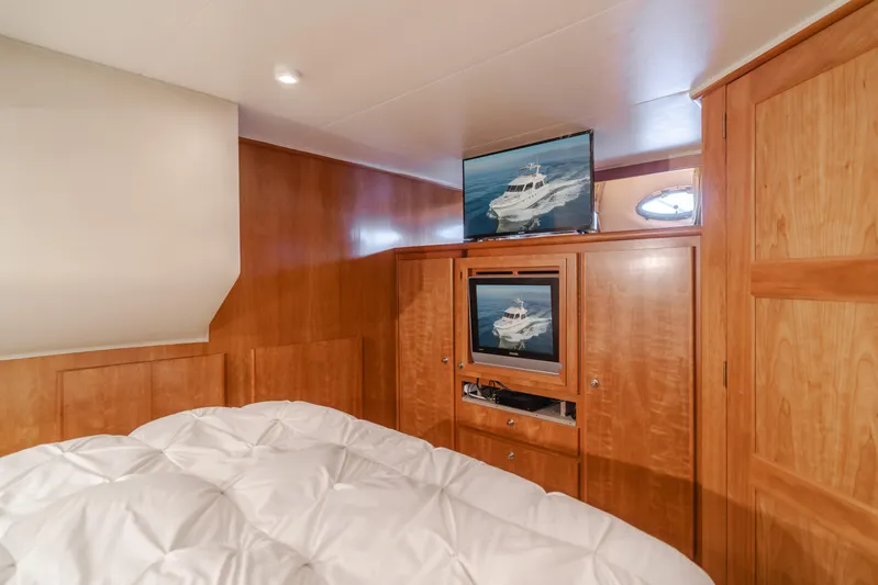 Love Life Yacht Photos Pics Luxurious 2007 Navigator Pilothouse bedroom with wood paneling and dual TVs.