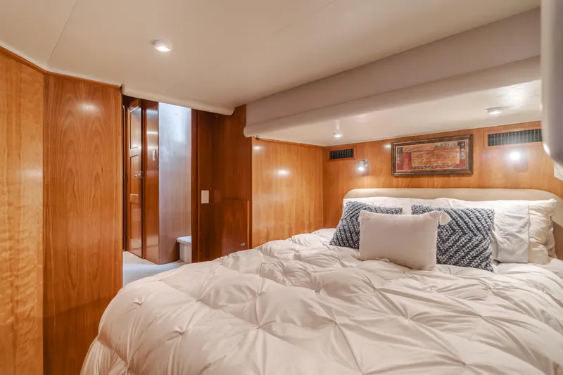 Love Life Yacht Photos Pics Luxurious bedroom in 2007 Navigator Pilothouse yacht with wood paneling and cozy bedding.