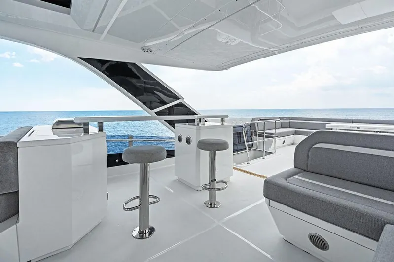 Triple T Yacht Photos Pics Luxurious 2022 Galeon 640 Fly yacht interior with ocean view, featuring modern seating and bar stools.