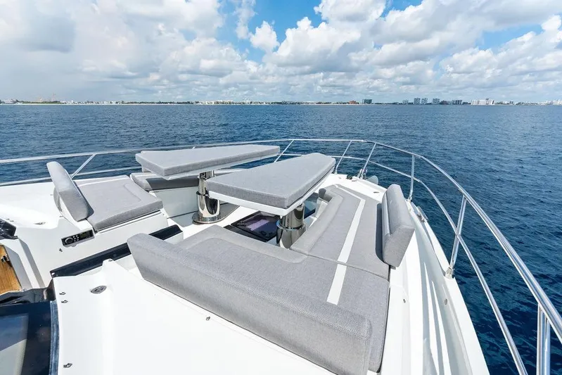 Triple T Yacht Photos Pics Luxurious 2022 Galeon 640 Fly yacht deck with seating, overlooking ocean and city skyline.