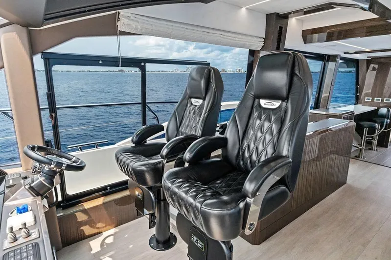 Triple T Yacht Photos Pics Luxurious interior of 2022 Galeon 640 Fly yacht with leather captain chairs and ocean view.