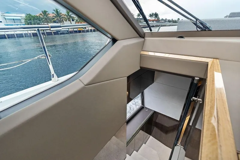 Triple T Yacht Photos Pics Interior view of 2022 Galeon 640 Fly yacht, showcasing elegant staircase and waterfront scenery.
