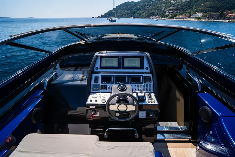  Yacht Photos Pics Cockpit of 2015 Riva 63 Virtus yacht with modern controls, overlooking serene blue waters.