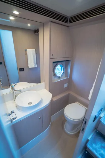  Yacht Photos Pics Luxurious bathroom in 2015 Riva 63 Virtus yacht with modern fixtures and porthole window.