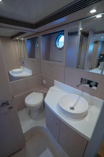  Yacht Photos Pics Luxurious bathroom interior of 2015 Riva 63 Virtus yacht with modern fixtures and porthole window.