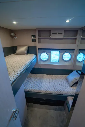  Yacht Photos Pics Luxurious cabin interior of 2015 Riva 63 Virtus yacht with twin beds and porthole windows.