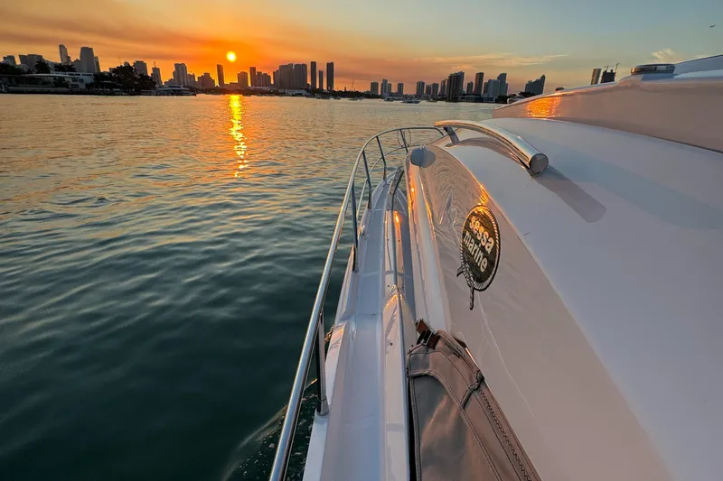  Yacht Photos Pics 2024 Sessa Marine C36 OB yacht cruising at sunset near city skyline.
